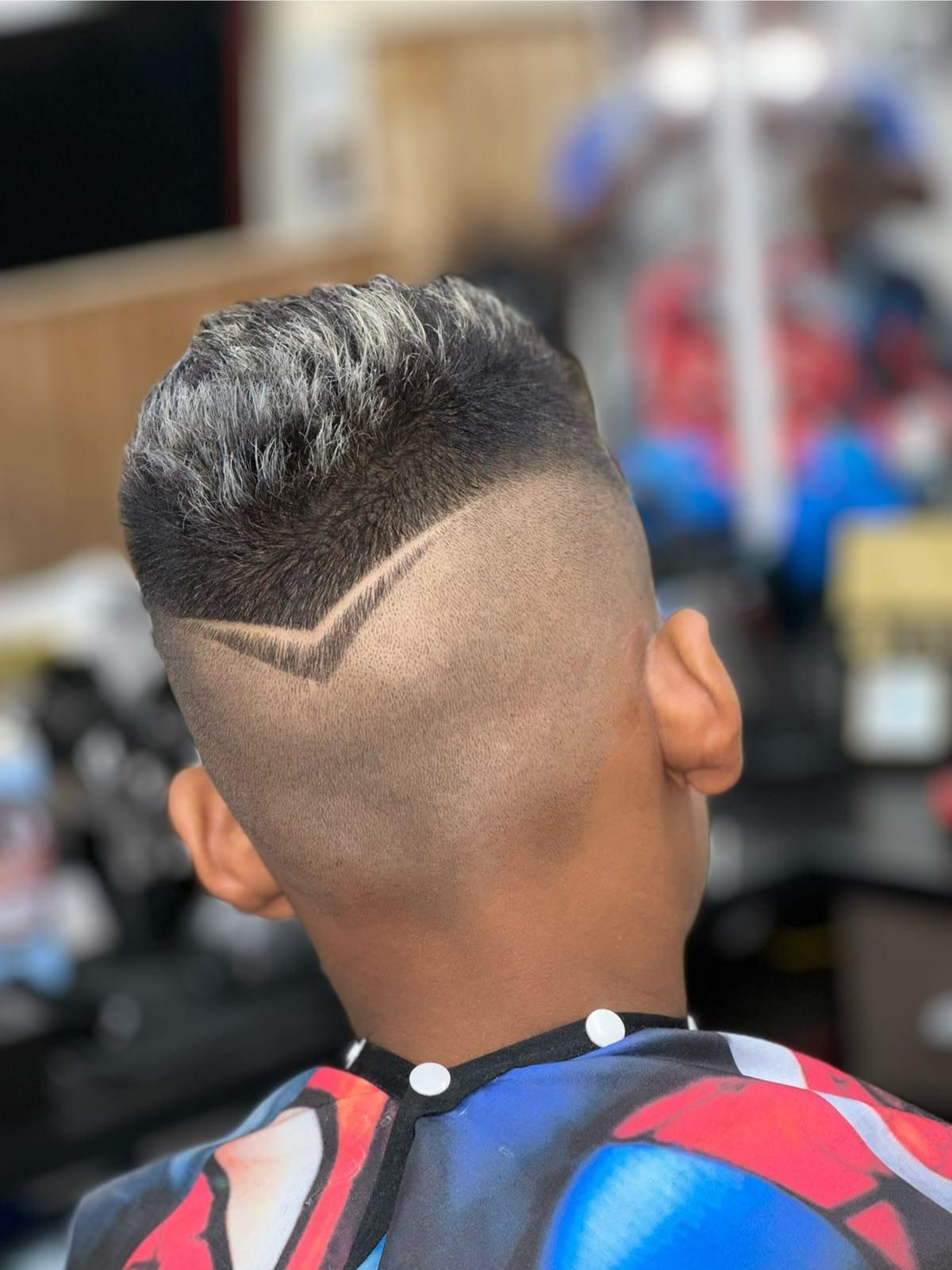 Corte masculino com mechas claras e dois riscos no degradê