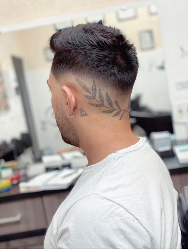 Corte masculino com degradê e desenho de folhas raspado na lateral