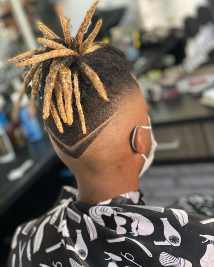 Dreads loiros presos no alto com desenho em V raspado na nuca