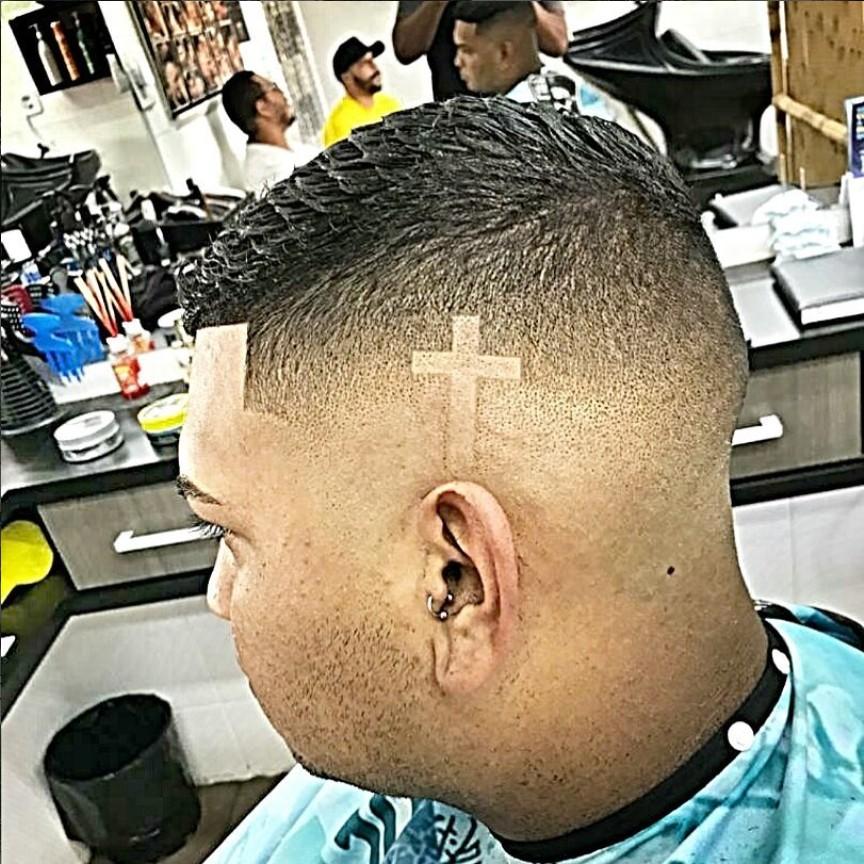 Corte masculino com degradê e cruz desenhada na lateral